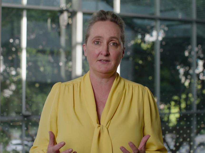 Qantas Group CEO Vanessa Hudson wearing a yellow top with trees behind her in public apology video