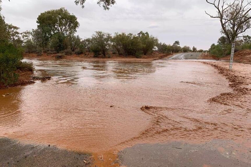 A big shallow pool of water on the road shows recent rainfall