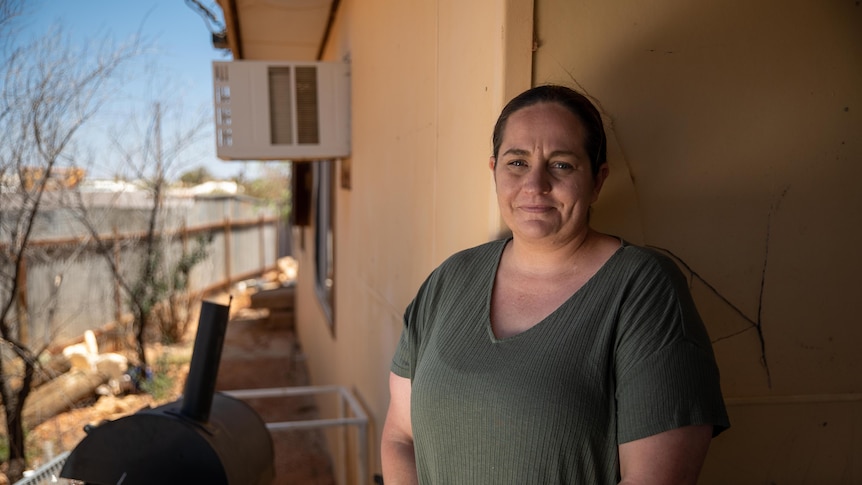 A woman standing out the front of her home