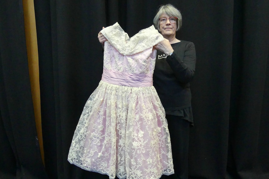 Dancer Shirley Gibson holds up a dress
