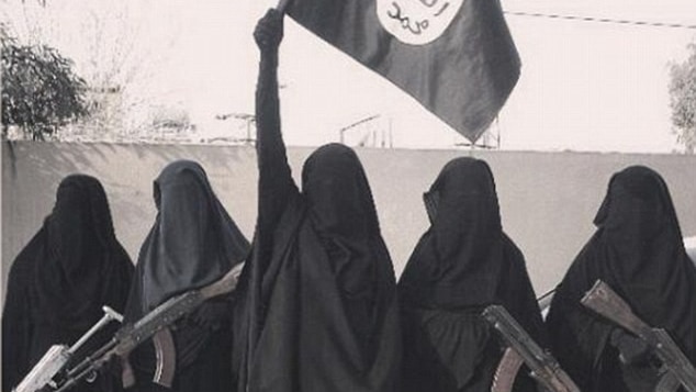 Five women wearing burquas - four hold machine guns, the middle woman holds an ISIS flag aloft.