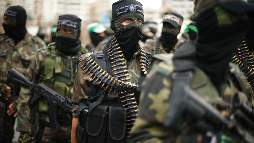 Members of al-Qassam Brigades march with ammunition