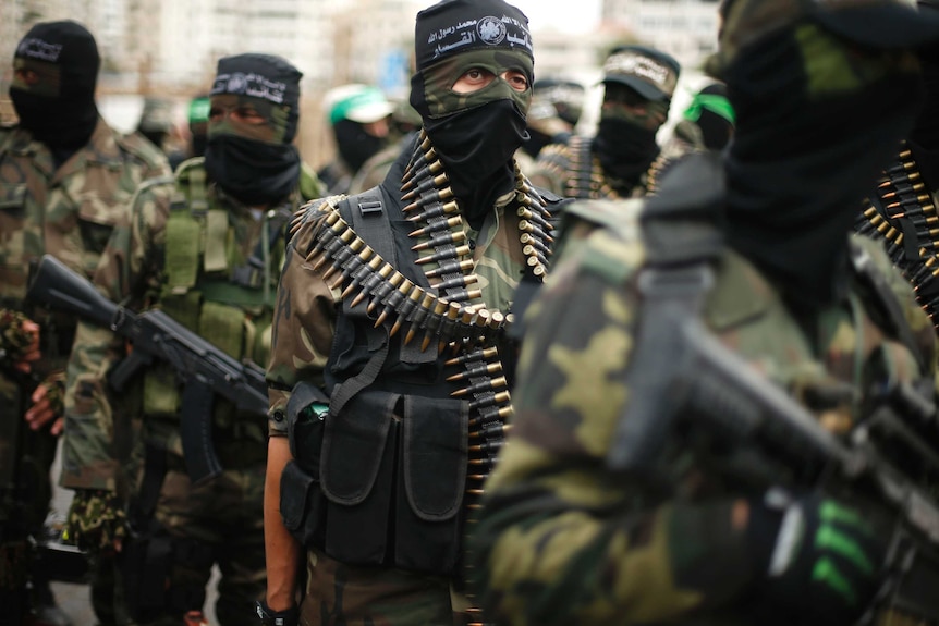 Members of al-Qassam Brigades march with ammunition
