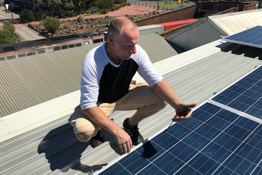 Darren Gee checks the roof-top solar system at Footscray Community Arts Centre