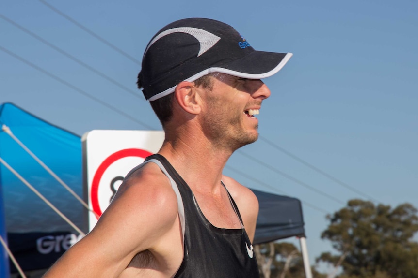 Side profile of a man in a cap and running singlet