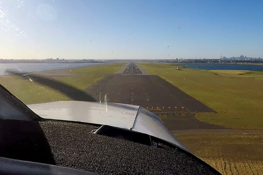 The view looking towards Sydney Airport's runway from a plane about to land, with water either side.