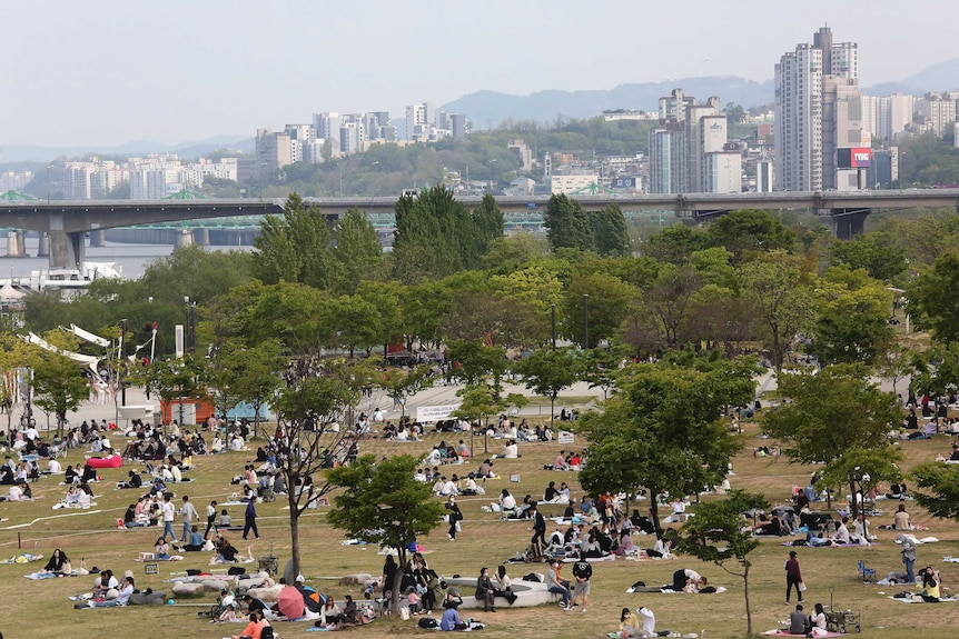 People enjoy at a public park on the Han River in Seoul, South Korea, in April 2020.