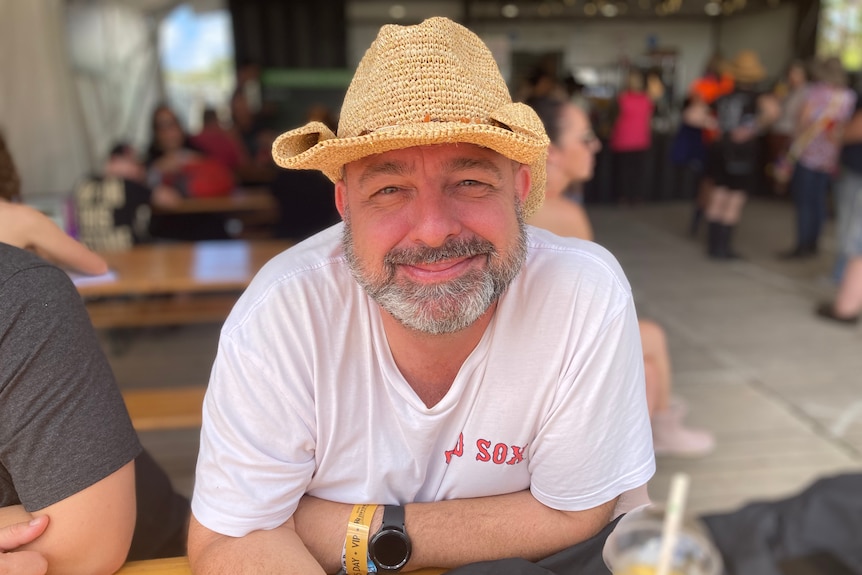 A man in a straw hat, smiling