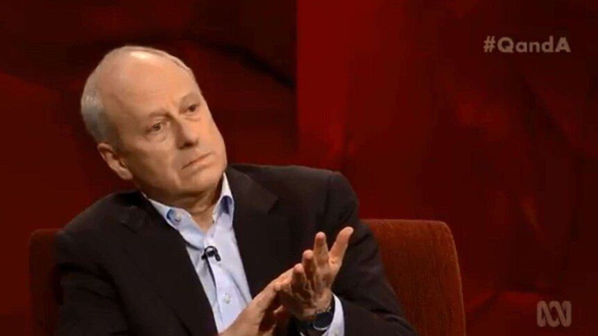 Michael Sandel clasps his hands together and purses his lips as he stares intently at the Q&A audience.