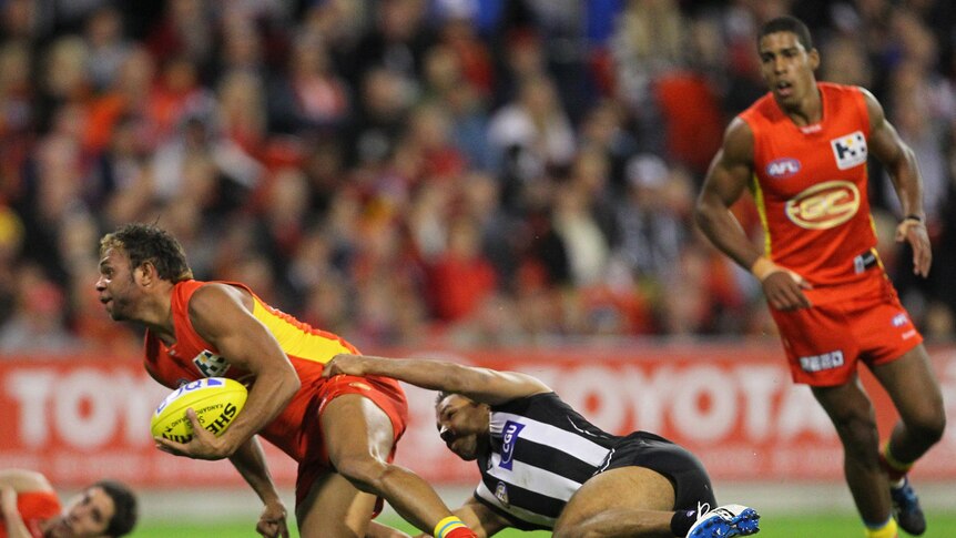No you don't ... Collingwood's Andrew Krakouer (right) tackles a marking Rex Liddy (left).
