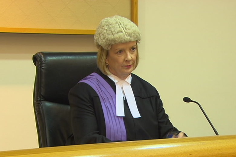 A woman with blonde hair wearing a short judge's wig