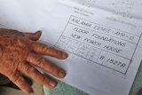 Older man's hand with architectural plans.
