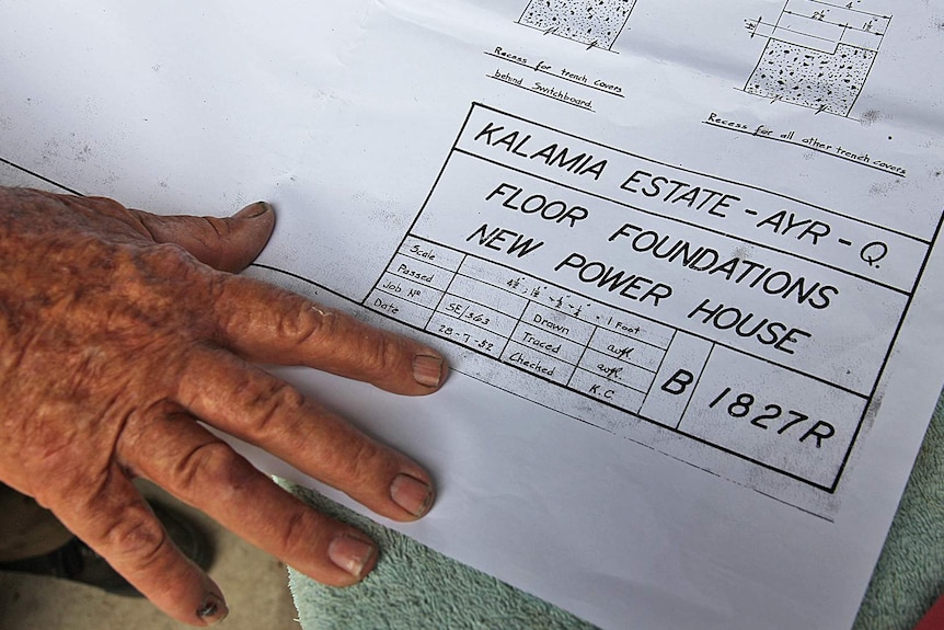 Older man's hand with architectural plans.
