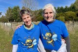 Two smiling woman wearing bee t-shirts.