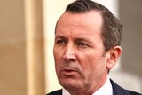 WA Premier Mark McGowan speaks at a media conference outside parliament, he wears a red tie and suit