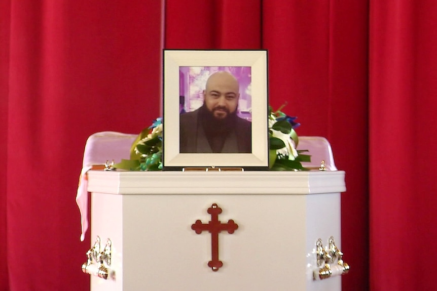 the photograph of a man on top of a coffin inside a church