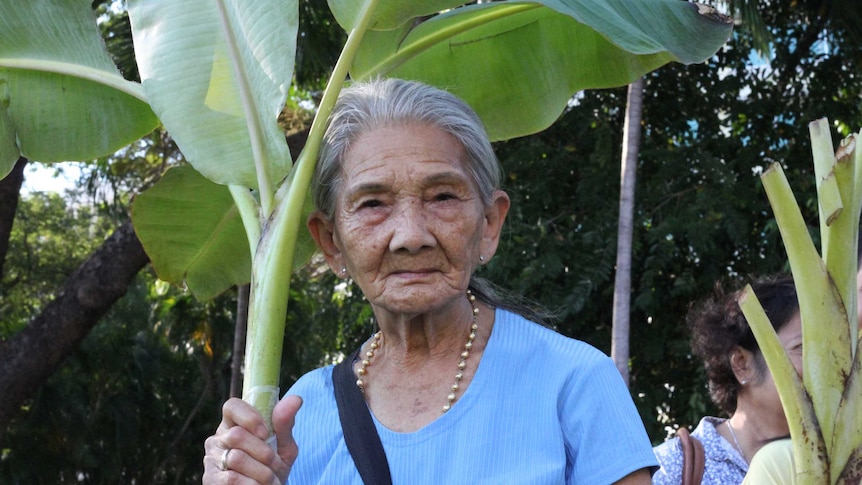 An old woman with banana leaves.