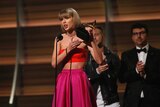 Taylor Swift holds award on stage