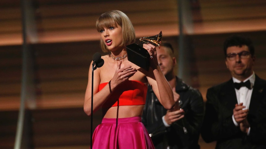 Taylor Swift holds award on stage