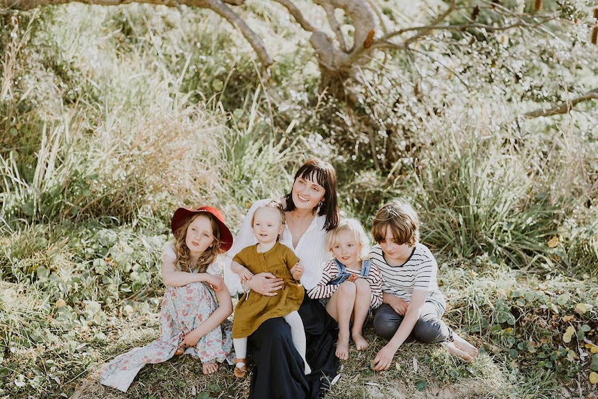 Jodi with her four children with bush behind them who paid for a family holiday with the proceeds from selling her old clothes.