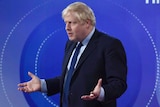 British Prime Minister Boris Johnson holds his arms up and shrugs during the BBC's live broadcast of Question Time.