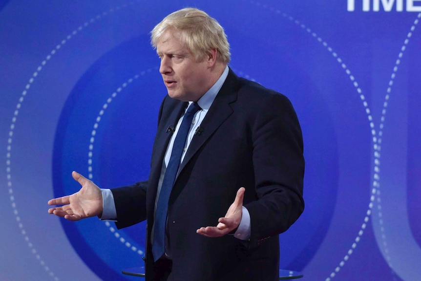 British Prime Minister Boris Johnson holds his arms up and shrugs during the BBC's live broadcast of Question Time.