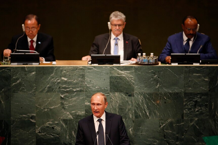 Vladimir Putin stands at a lectern in the UN Headquarters chamber 