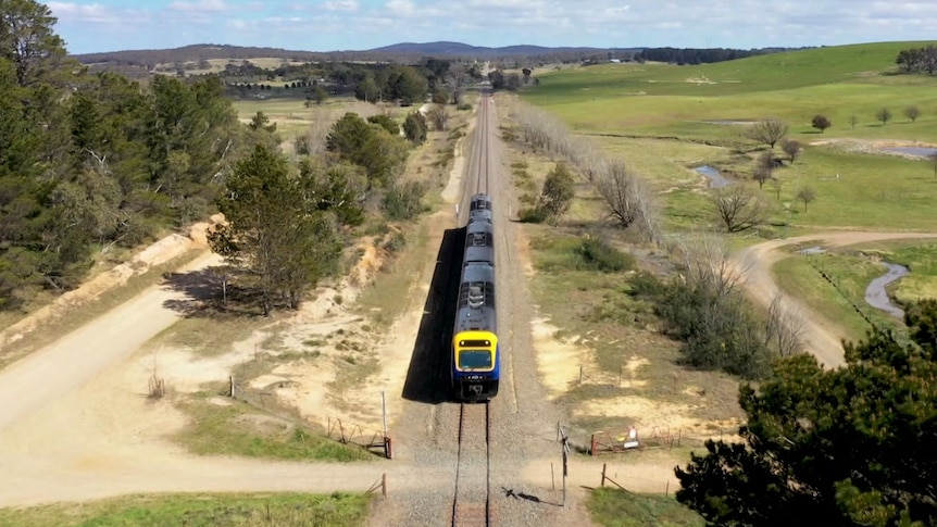 A commuter train moving along the tracks.