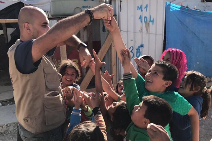 Dr Naveed Iqbal playing a game with a group of children at a refugee camp in Lebanon.