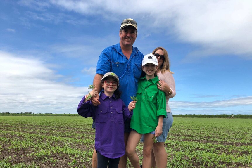 man with daughters in bean paddock