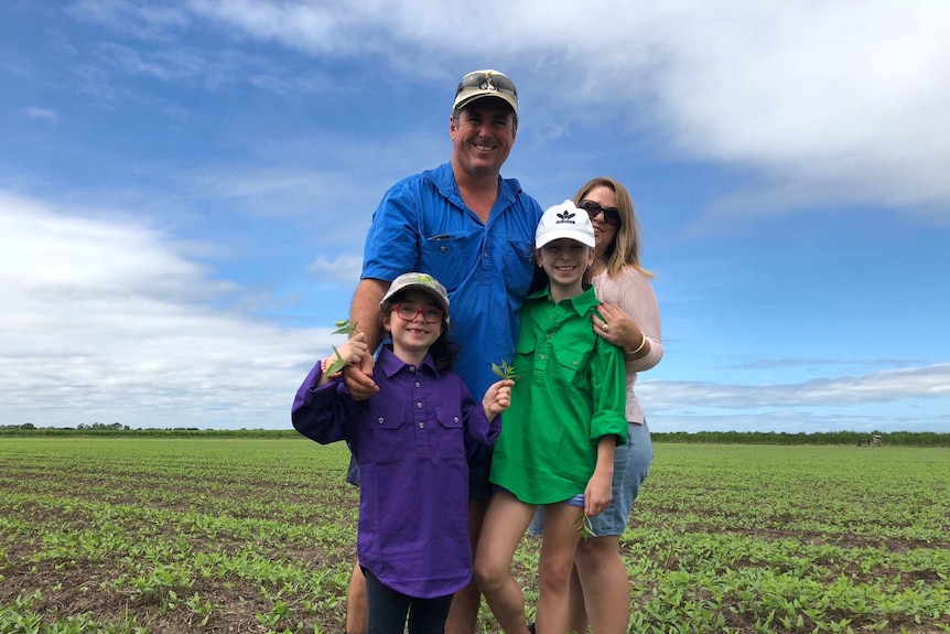 man with daughters in bean paddock