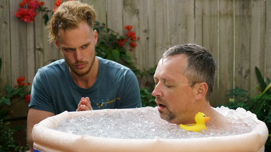 A man sits in a bath of ice