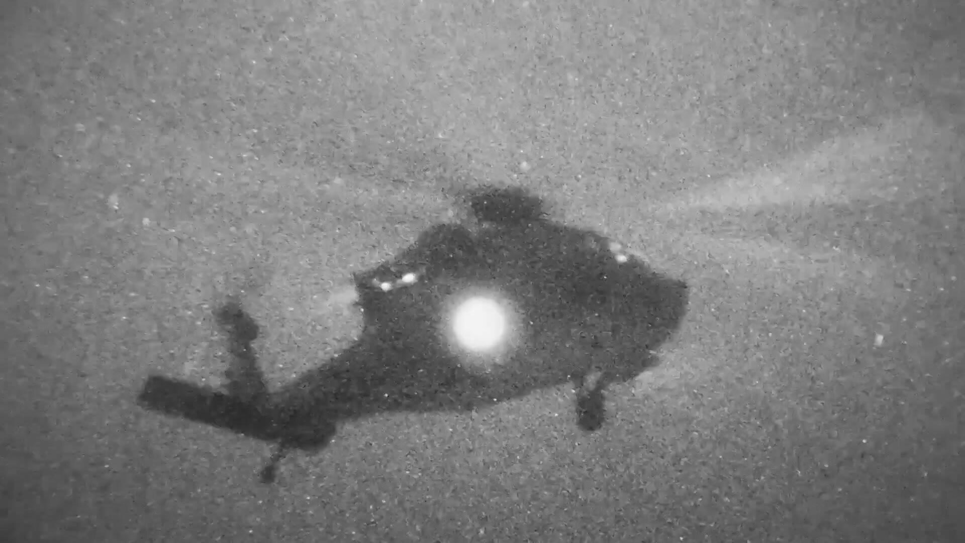 Grainy night-vision video frame of helicopter.
