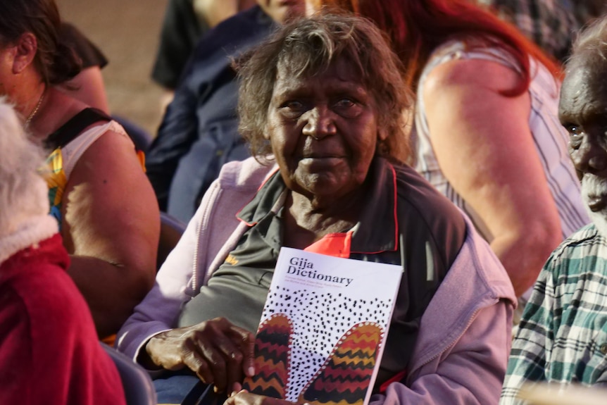 an older Indigenous woman holds a Gija dictionary