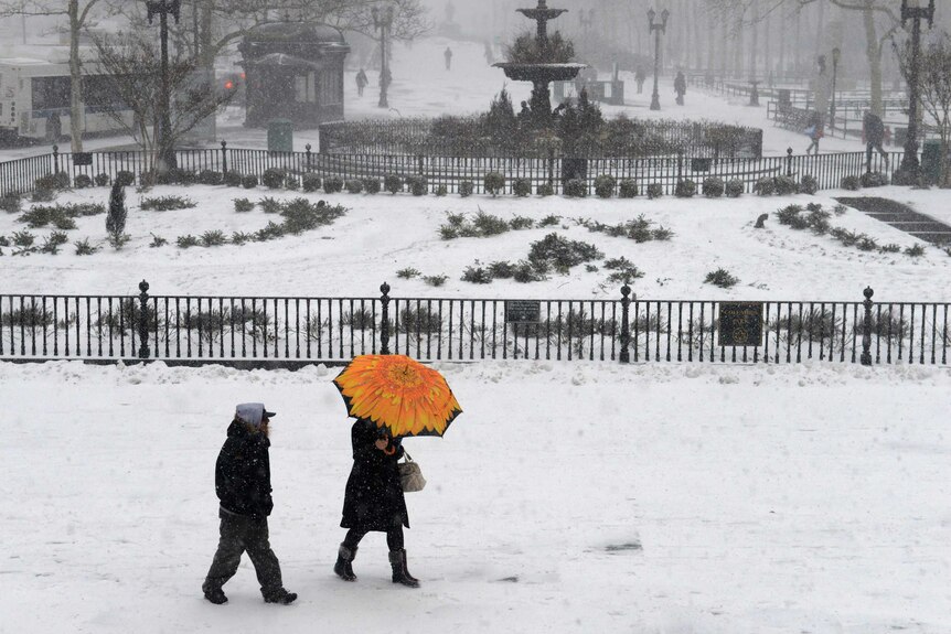People walking while it snows in Brooklyn