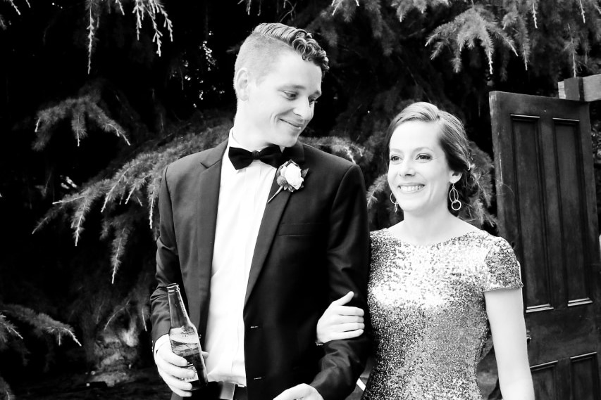 A man wearing a suit and a woman in a sparkly gown walking with linked arms