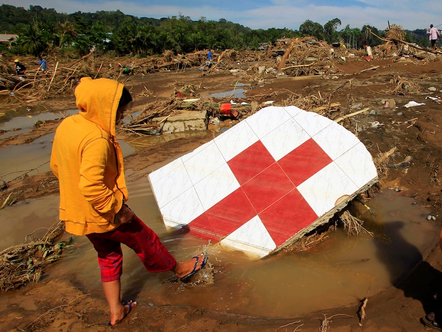 Grim task ... a flood survivor surveys storm damage in Cagayan de Oro.