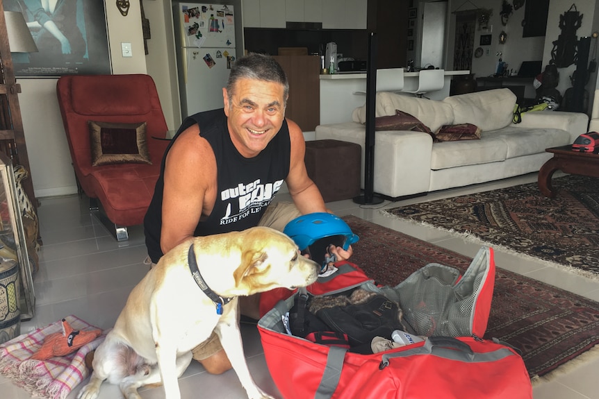 Charles Werb packing a bag preparing to leave for Russia with his dog Mawson.