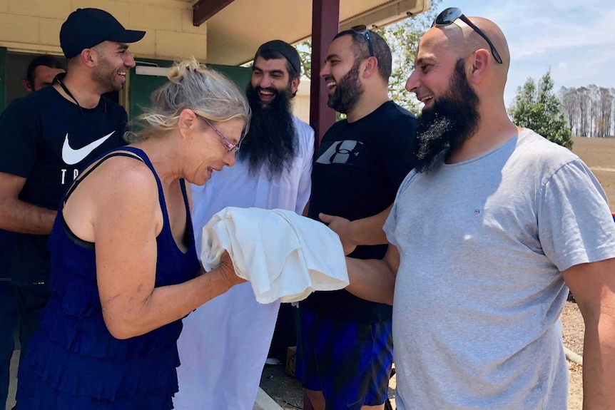 A woman receives an abaya from a Muslim man