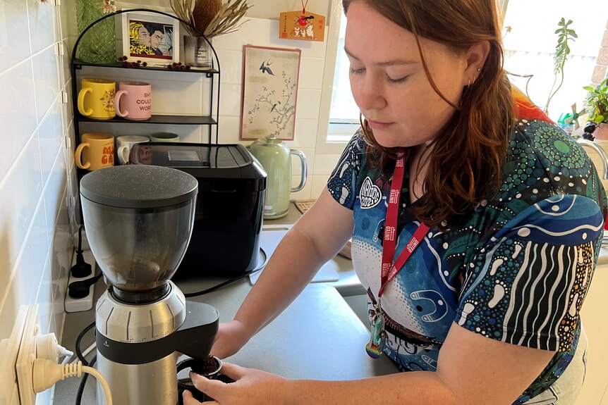a picture of a woman using a coffee machine 