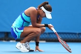 Heather Watson crouches down in pain on the tennis court