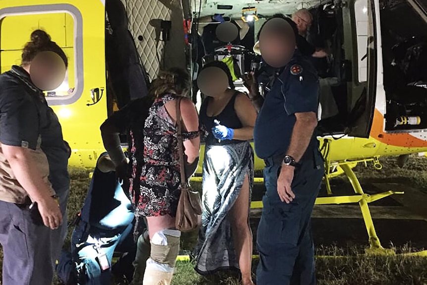 Paramedics helping people into a helicopter