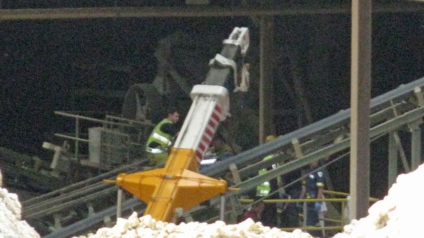 Ambulance crew works on a man trapped in machinery at K and D's brick plant in Hobart.
