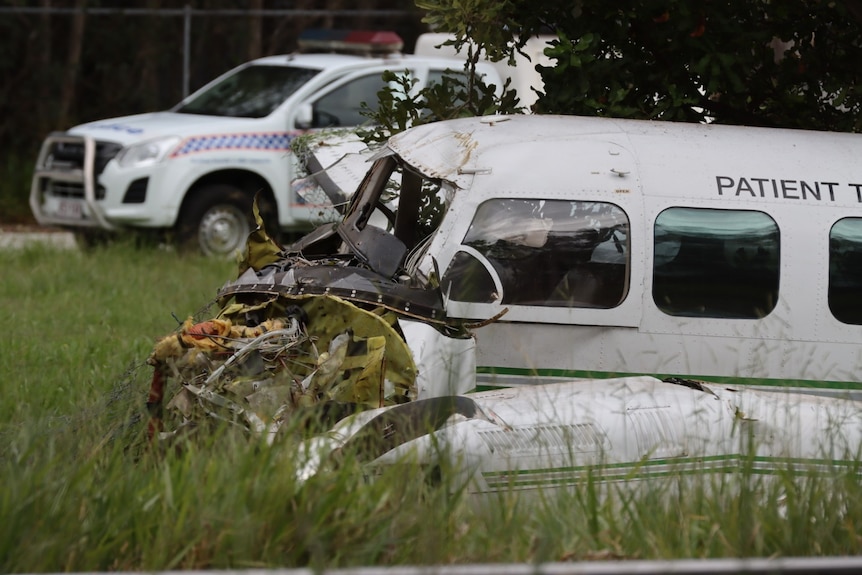 a mangled plane that has crashed in a grassy lot