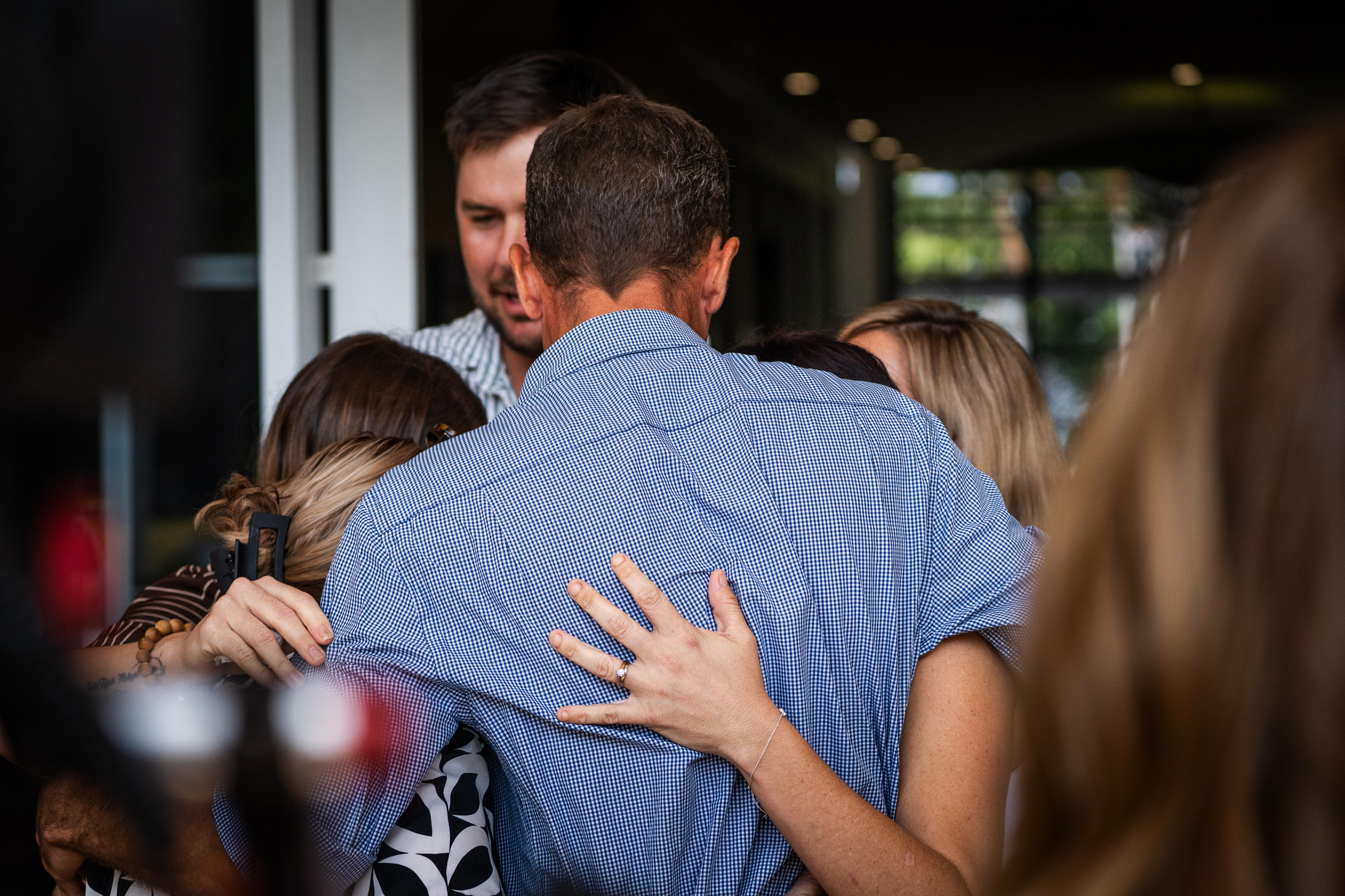 Family members hug outside of the courthouse.