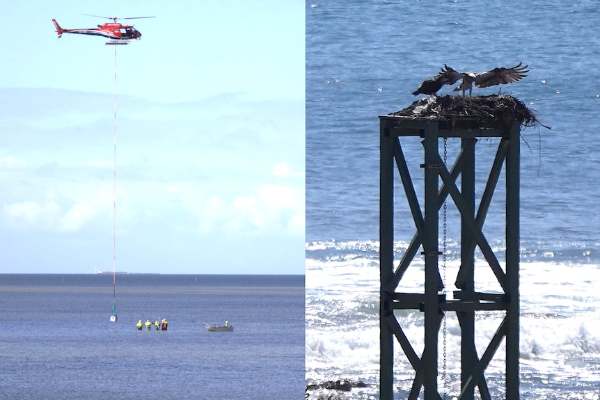 Helicopter lowering a pole, far out to sea, with people in high-vis jackets standing near to guide the pole, dinghy nearby
