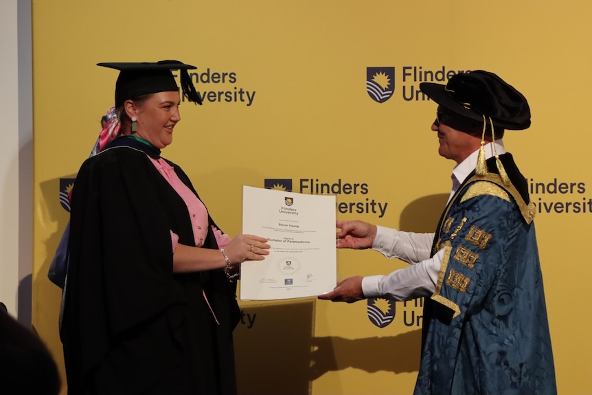 Woman receives certificate after graduating university course 