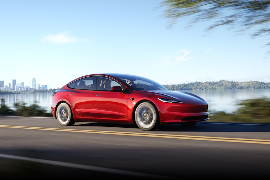 Photo of a red tesla driving 