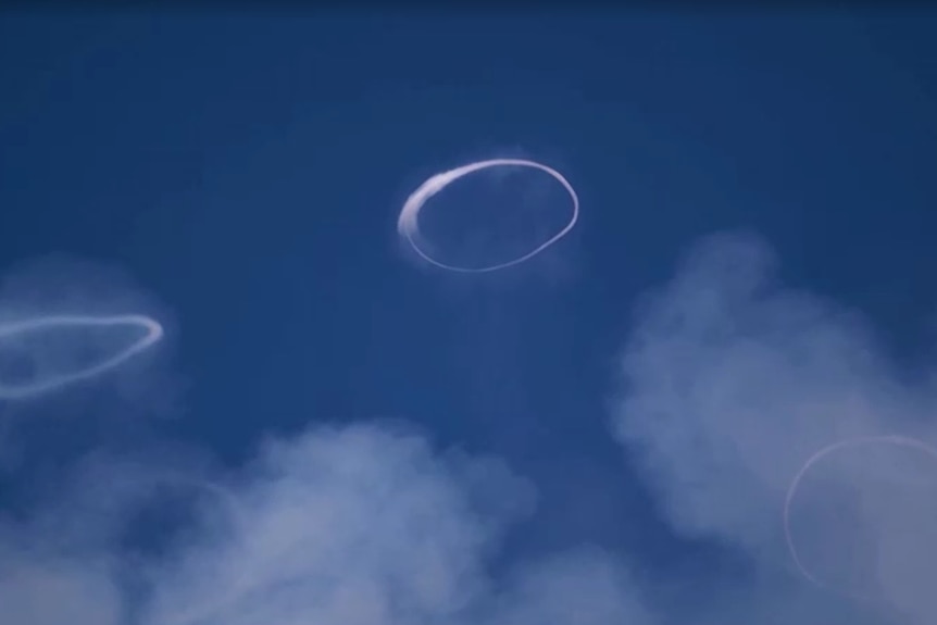 Two white rings can be seen in the sky.