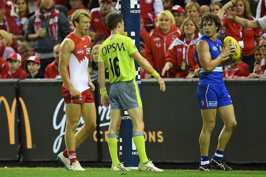 Swans' Callum Mills speaks to umpire Brendan Hosking after Bulldogs' Liam Picken was awarded a free kick
